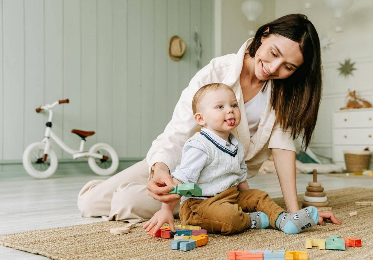 Mamma single gioca con suo figlio piccolo in casa.